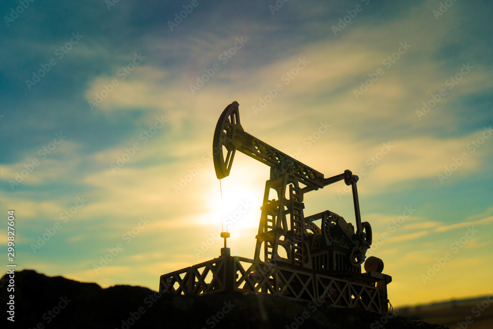 Oil pump on a sunset background. Oil production, fuel, natural resources. - obrazy, fototapety, plakaty 