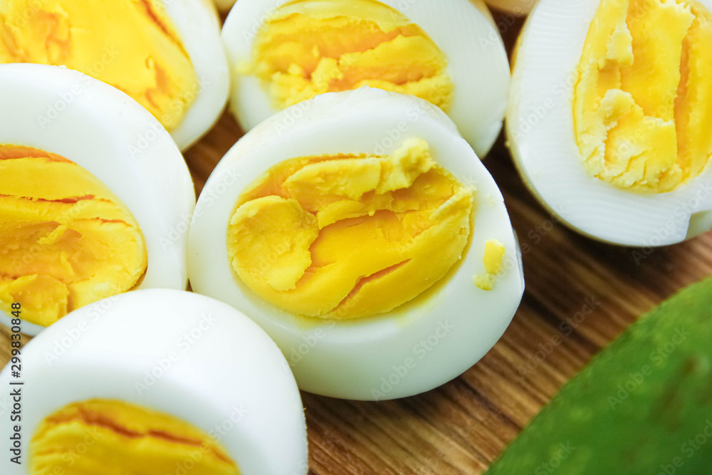 boiled eggs with avocado on a wooden board.