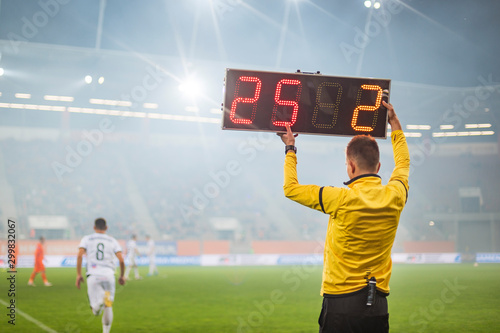 Technical referee shows players substitution during soccer match. photo