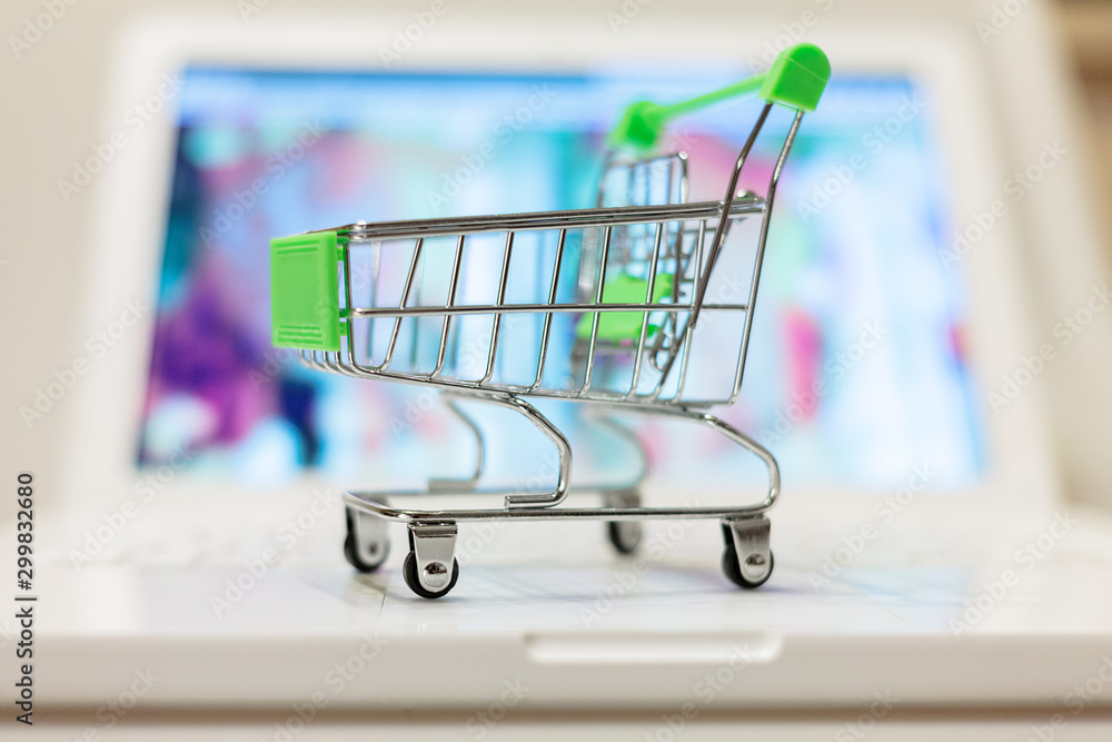 supermarket shopping cart on laptop background close-up, macro, online shopping concept and purchasing power, consumer shopping cart supermarket shopping cart on laptop background close-up, macro, online shopping concept and purchasing power, consumer shopping cart