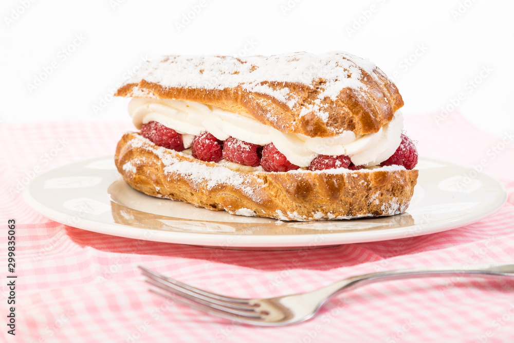 Raspberry Cream Eclair with strong Back Light on Dessert Dish with Pink Gingham Place Mat Raspberry Cream Eclair with strong Back Light on Dessert Dish with Pink Gingham Place Mat