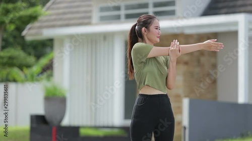 pretty young asian woman warm up and exercising in front of her house outdoor photo