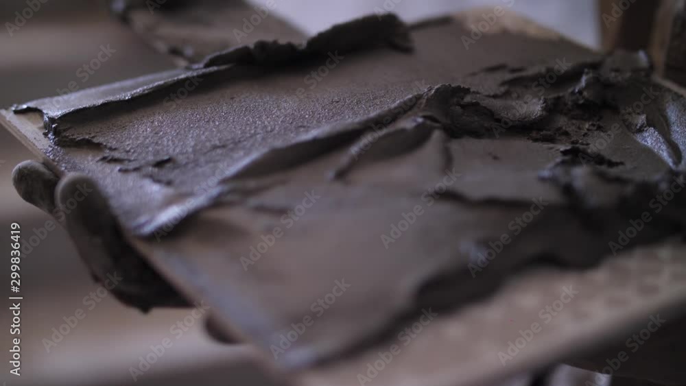 laying ceramic tiles, hands close-up, spatula in hand laying ceramic tiles, hands close-up, spatula in hand