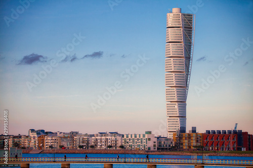 Turning torso of malmö skyline with bridge blue sky and sea photo