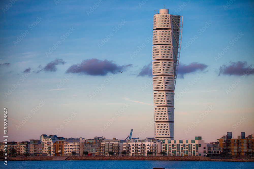 Turning torso of malmö skyline with blue sky and few clouds and sea - obrazy, fototapety, plakaty 