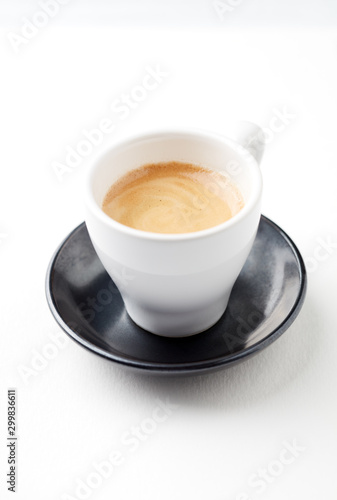 Cup of coffee on white paper background. Close up. Copy space.