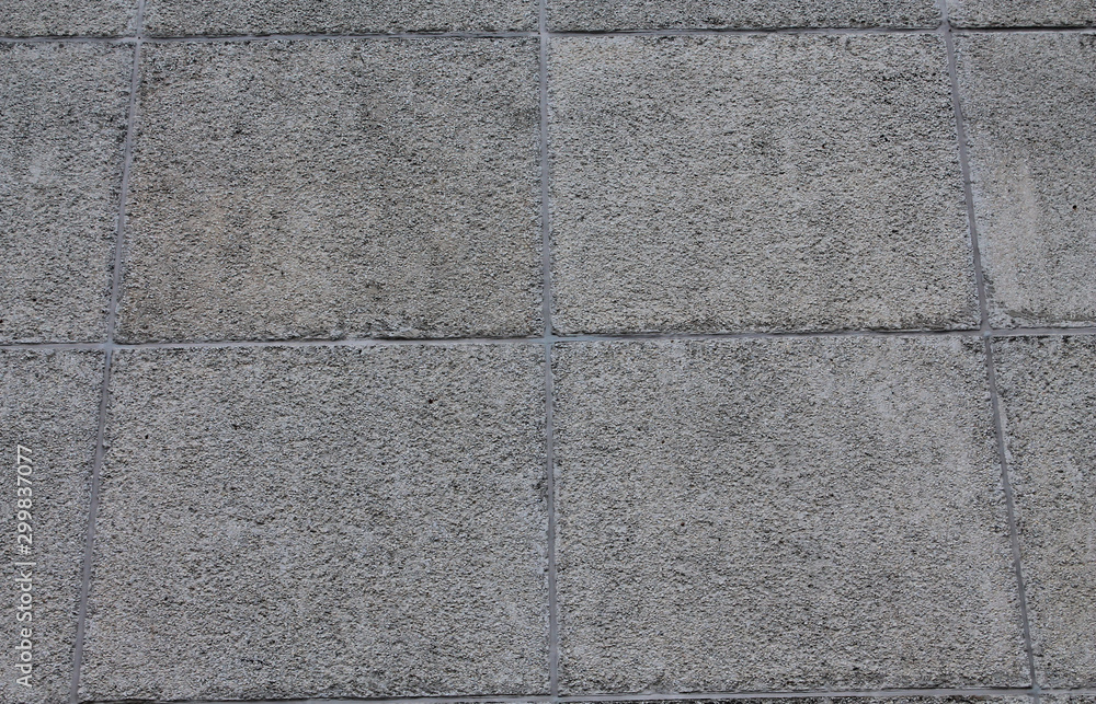 Fototapeta premium Gray concrete wall of a prefabricated house. Squares. Concrete and stone.