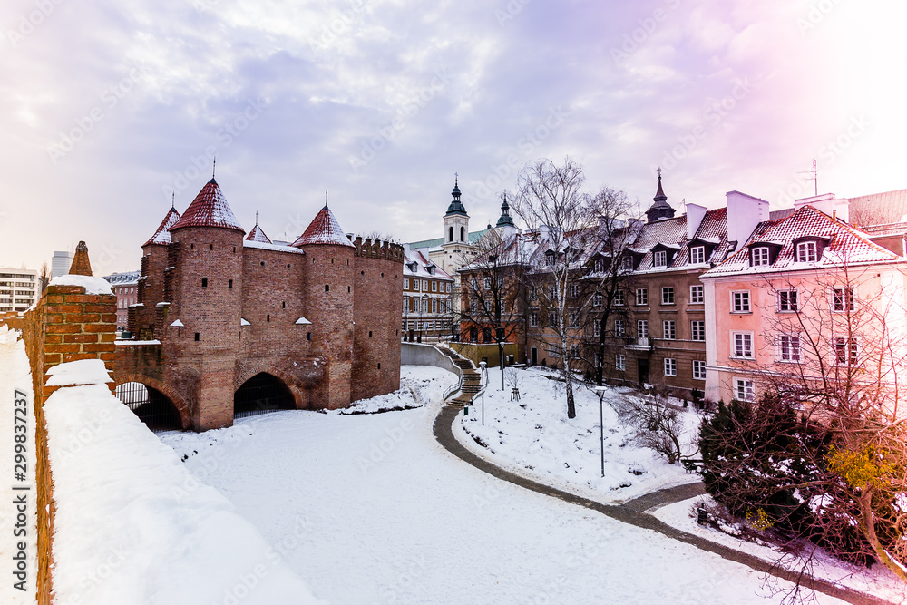 Warsaw Barbacan fortress castle in winter is in the capital city of Poland. Old town is the historic center of Warsaw.. Winter, travel , colored light leaks coming from the side .