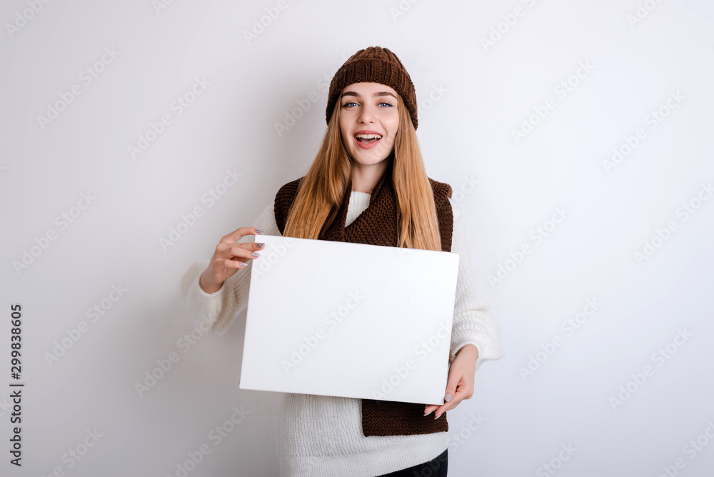 Naklejka premium Young woman holding a blank sign in front oh her face