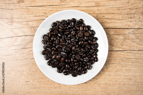 coffee beans in a bowl on wooden background