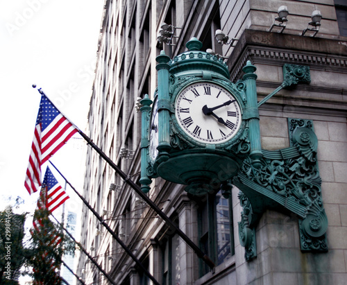 Chicago, old blue clock on the street corner and flags