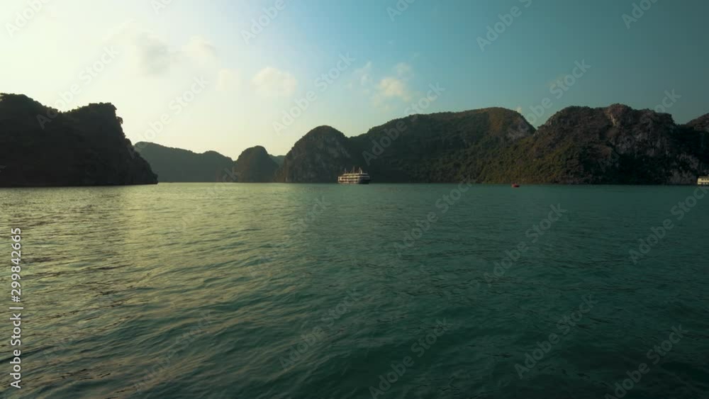 A junk boat anchored in beautiful Ha Long Bay, Vietnam at sunset A junk boat anchored in beautiful Ha Long Bay, Vietnam at sunset
