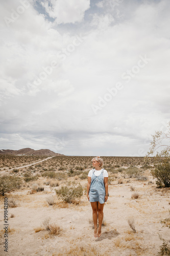 Young woman jumping mid-air in desert landscape, Joshua Tree National Park, California, USA
