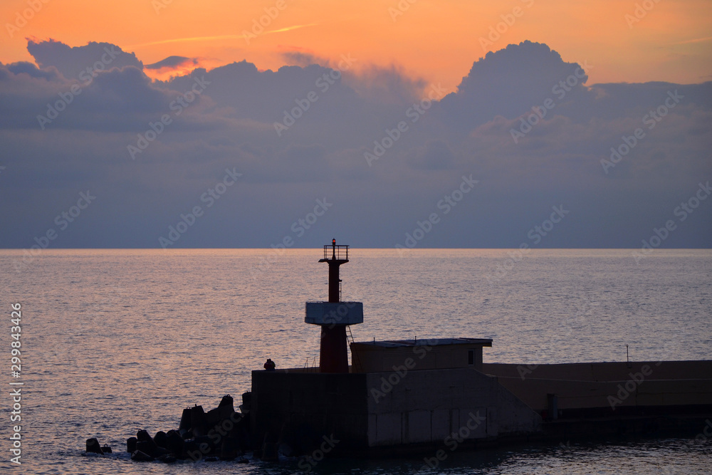 Fototapeta premium seascape with a lighthouse at sunset