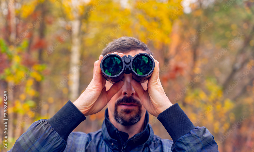 a man looks through binoculars. close-up. cold tone. a man looks through binoculars. close-up. cold tone.