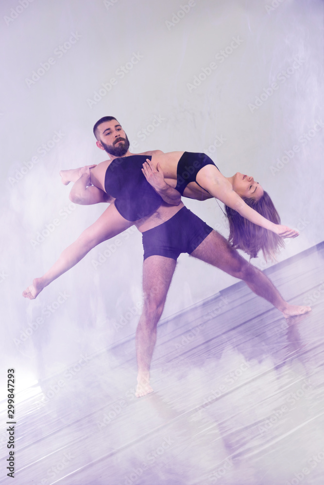 Two Young modern dancers dancing in the studio. Sport, dancing and urban culture concept. Group of young dancers performing on the stage. Effective performance. beautiful dance. Two Young modern dancers dancing in the studio. Sport, dancing and urban culture concept. Group of young dancers performing on the stage. Effective performance. beautiful dance.