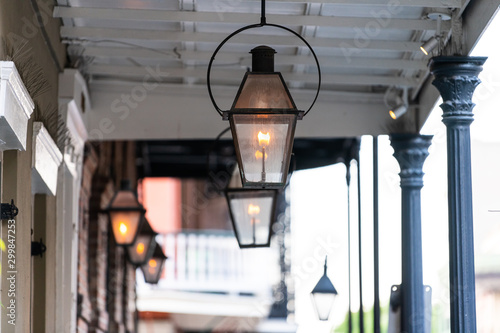 фотографія New Orleans typical street covered sidewalk with row of flame in gas lanterns la