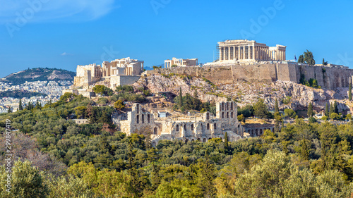 Acropolis of Athens in summer, Greece. View of famous Parthenon and Odeon of Herodes. Urban landscape of old Athens with classical Greek ruins. Scenic panorama of remains of ancient Athens city.