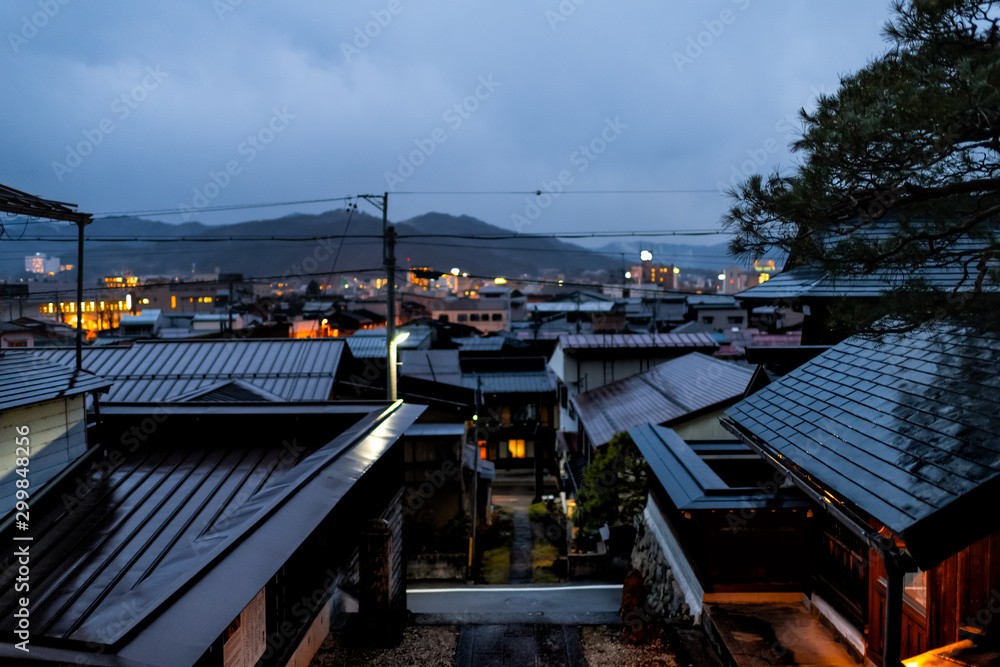 Takayama, Japan Gifu prefecture in Japan with view of skyline cityscape of roof mountain town village in dark night with illuminated buildings