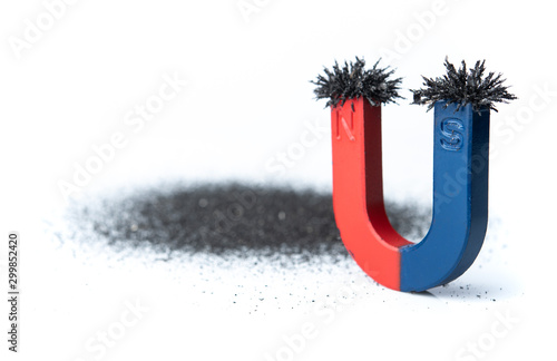 Foto Horseshoe magnet attracting iron powder on white background
