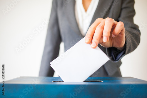 elections - The hand of woman putting her vote in the ballot box photo