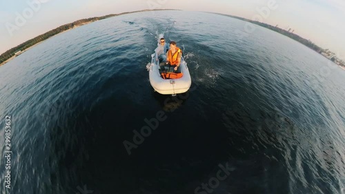 Front view of men in the autoboat crossing the lake photo