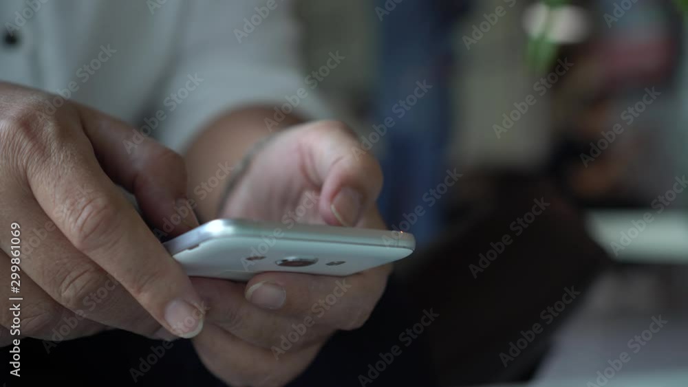 Online searching social networks by Smartphone Concept: Hand of young man pointing finger on screen smart phone, using hand touching screen or typing sms message to his friends on table in home Online searching social networks by Smartphone Concept: Hand of young man pointing finger on screen smart phone, using hand touching screen or typing sms message to his friends on table in home
