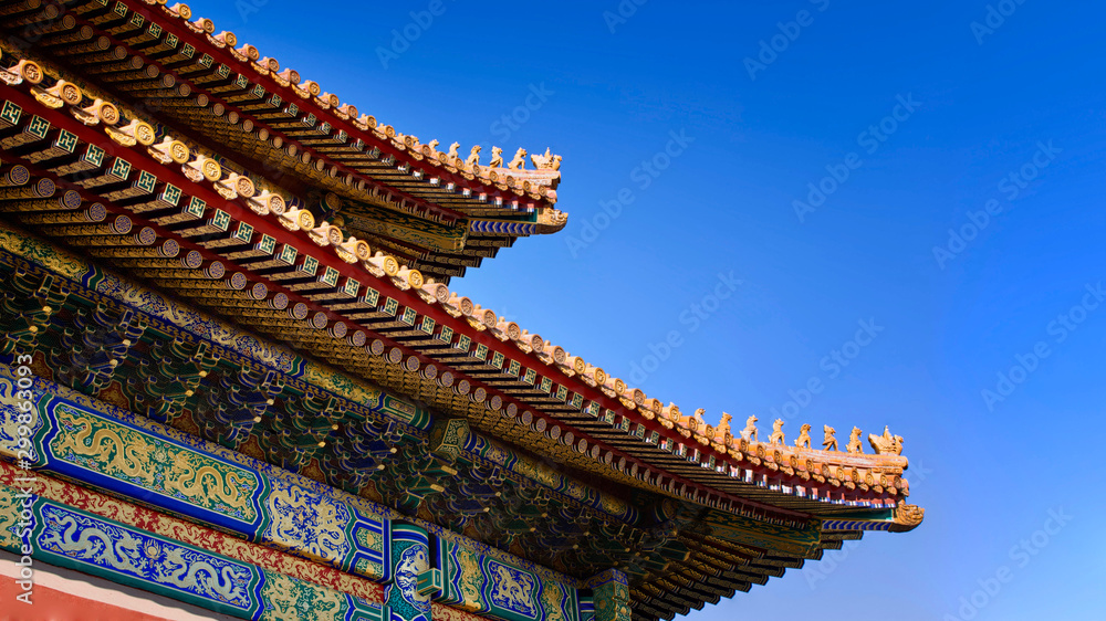curved roofs in traditional Chinese style with figures on the blue sky background. The Imperial Palace in Beijing curved roofs in traditional Chinese style with figures on the blue sky background. The Imperial Palace in Beijing