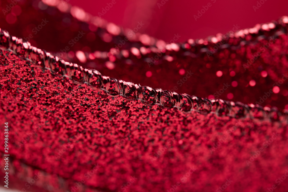 Obraz premium Macro abstract texture view of glittering defocused red fabric ribbon with bokeh