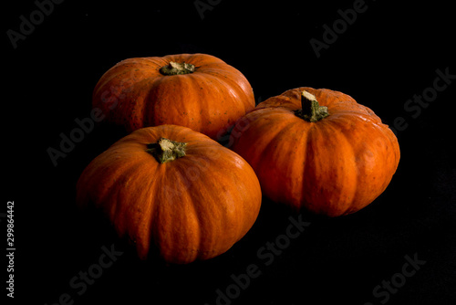 Small seasonal orange pumpkins with textured background with black background