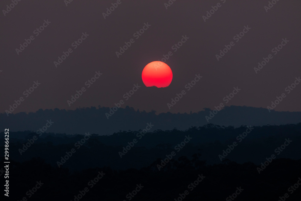 A vivid orange sun due to bushfire smoke in The Blue Mountains, New South Wales, Australia. A vivid orange sun due to bushfire smoke in The Blue Mountains, New South Wales, Australia.