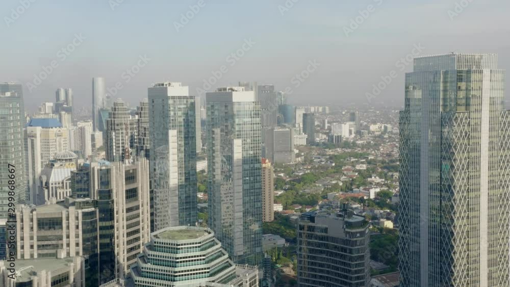 Contemporary iconic cityscape, Jakarta aerial push in towards skyscraper office towers & modern city downtown urban scene. Contemporary iconic cityscape, Jakarta aerial push in towards skyscraper office towers & modern city downtown urban scene.