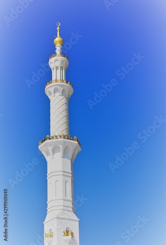 minaret of grand mosque by clear bright blue sky