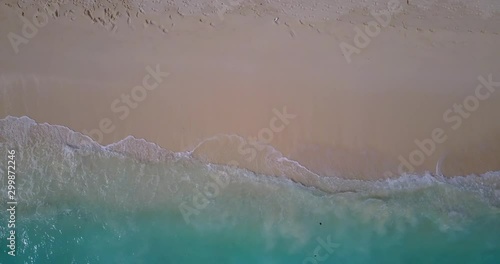 abstract sea waves and sandy beach background, footprints on the white sand, foamy waves of turquoise sea photo
