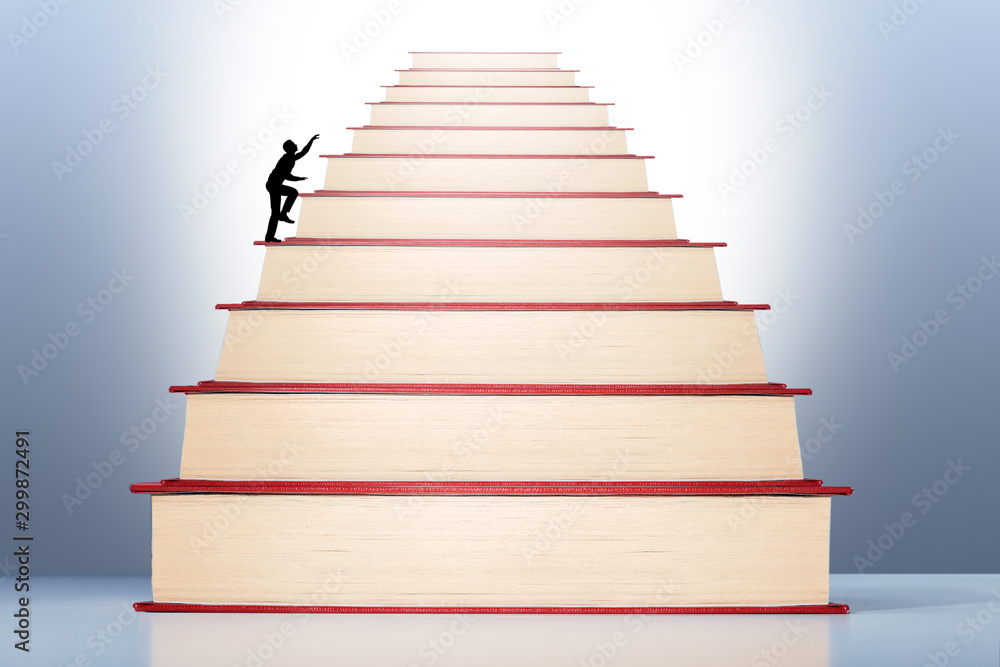 Businessman walking on stack of Books to knowledge, success, career. Through education and learning to success concept. Businessman walking on stack of Books to knowledge, success, career. Through education and learning to success concept.