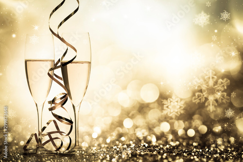 two champagne glasses with ribbons against holiday lights and fireworks - New Year celebrations