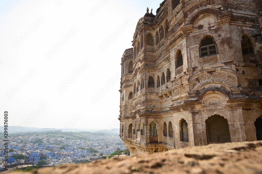 (Selective focus) View from above, stunning view of the beautiful Mehrangarh Fort in the foreground and the blue city of Jodhpur in the background. Jodhpur, Rajasthan, India.