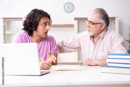 Old father helping his son in exam preparation