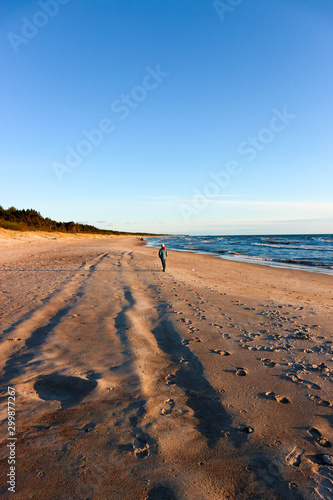 Boy on the sand beach of Baltic sea in Palanga, Lithuania in the search of amber