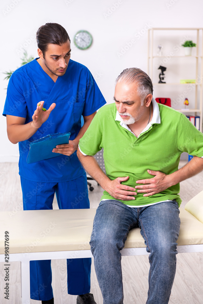Fototapeta premium Old man visiting young male doctor gastroenterologist
