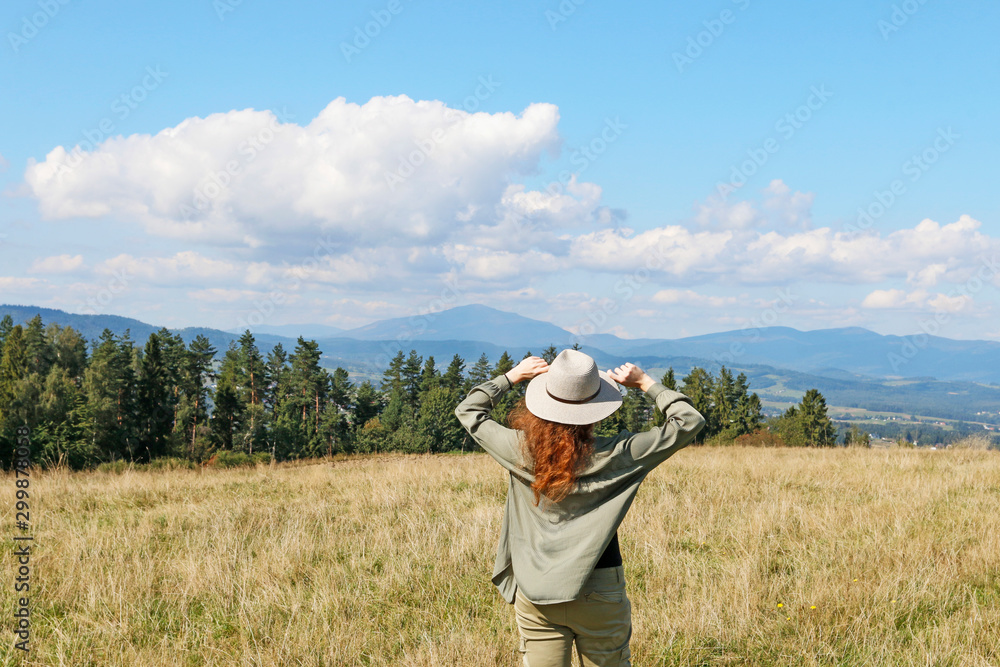 Young woman in a holiday hat looks at the beautiful landscape. Young woman in a holiday hat looks at the beautiful landscape.