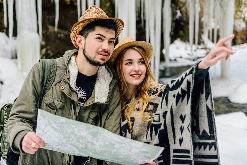 Φωτογραφία A pair of explorers travelers with a map in the winter mountains.