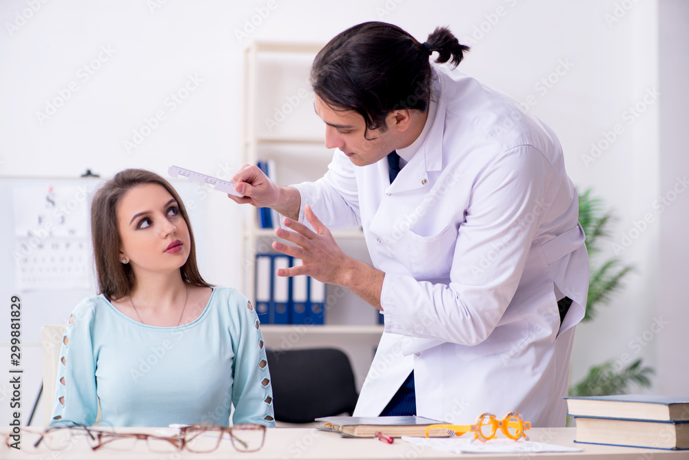 Fototapeta premium Young woman visiting male doctor oculist