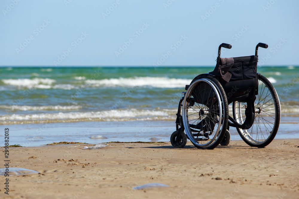 Fototapeta premium Wheelchair stands on the seashore