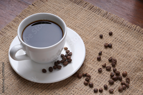 cup of coffee and coffee beans on jute