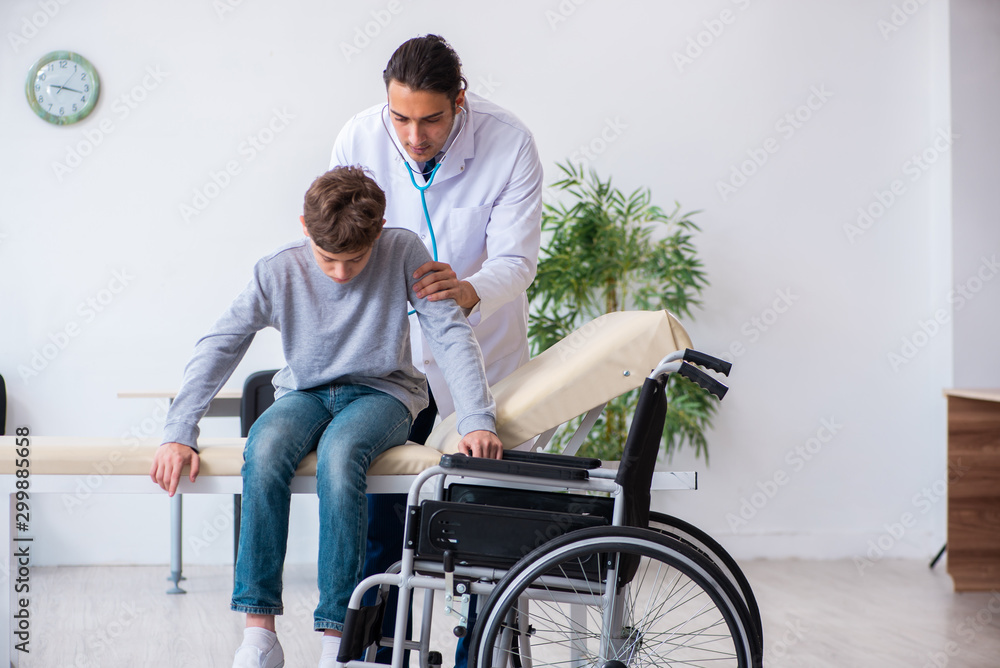 Young male doctor pediatrist and boy in wheel-chair Young male doctor pediatrist and boy in wheel-chair