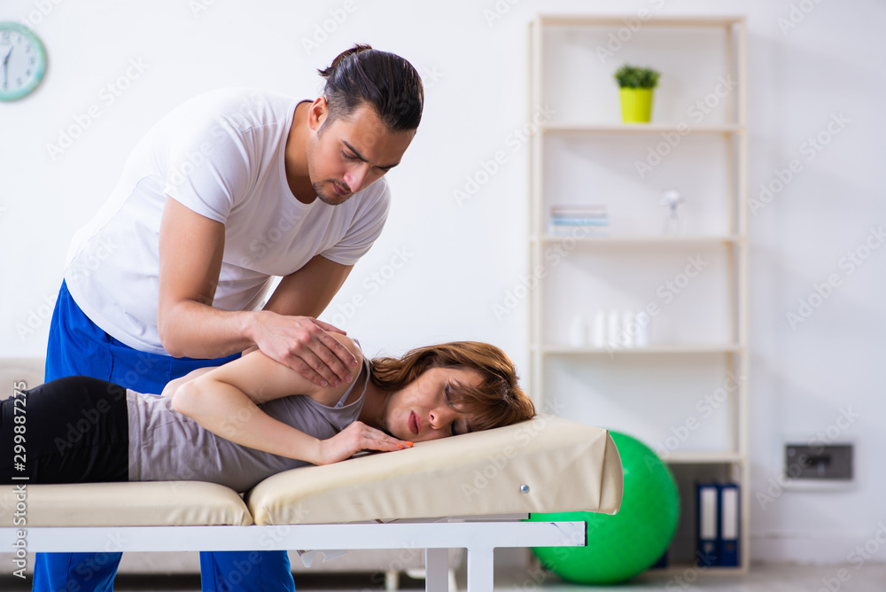 Fototapeta premium Young woman visiting male doctor physiotherapist