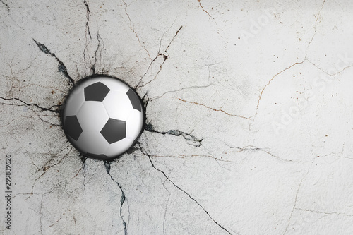 Sport soccer ball coming in cracked wall with grunge texture. photo