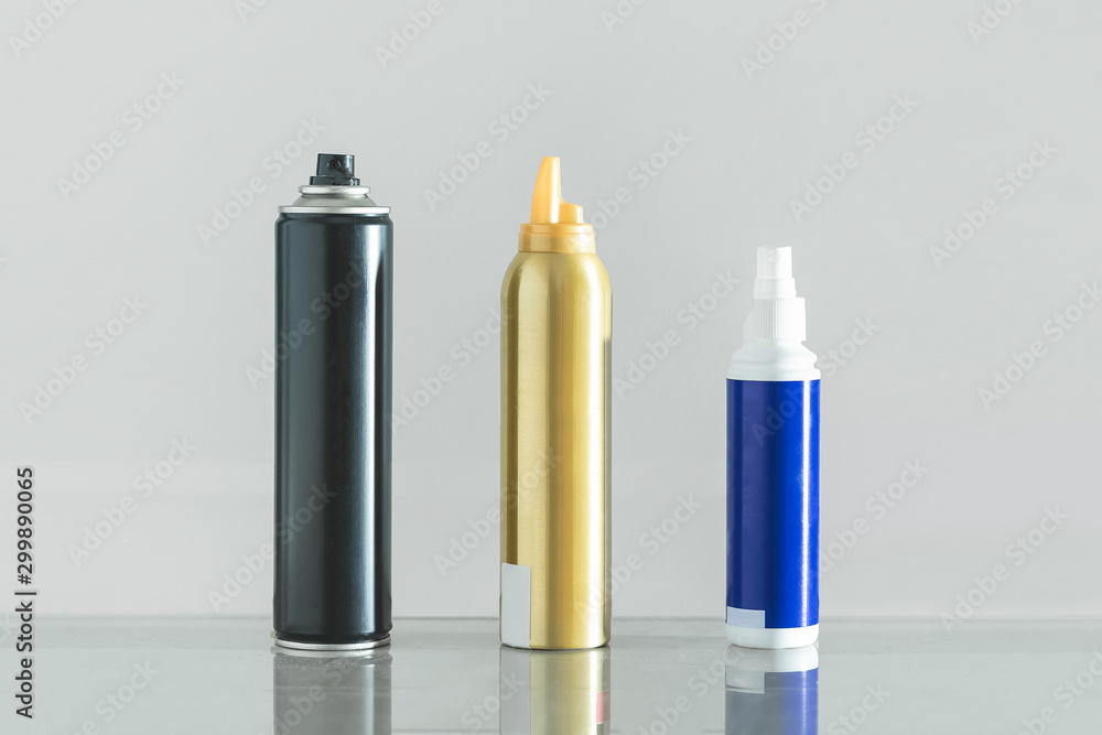 Three multicolored bottles of professional hair spray on white background. Three multicolored bottles of professional hair spray on white background.