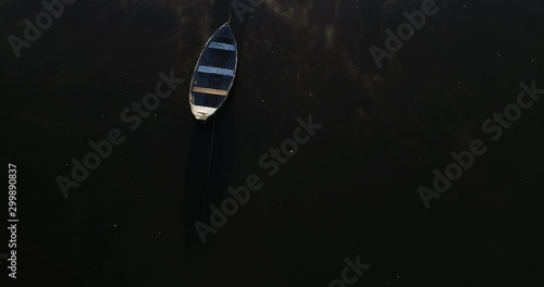 Aerial top view of old rowing boats. Flying senital over mooring boats at river. White fog moving over black water surface. Mercedes, Rio Negro, Uruguay photo